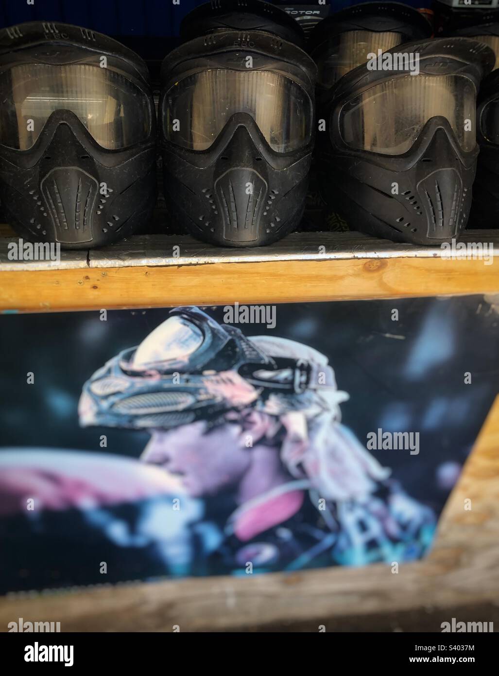 Helmets and poster at an outdoor paintball range Stock Photo