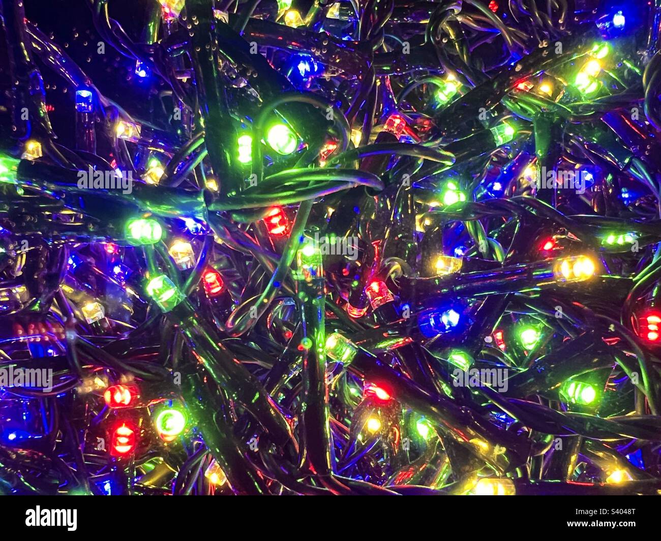 Coloured Christmas lights, a string of blue green yellow and red fairy lights for Christmas Stock Photo