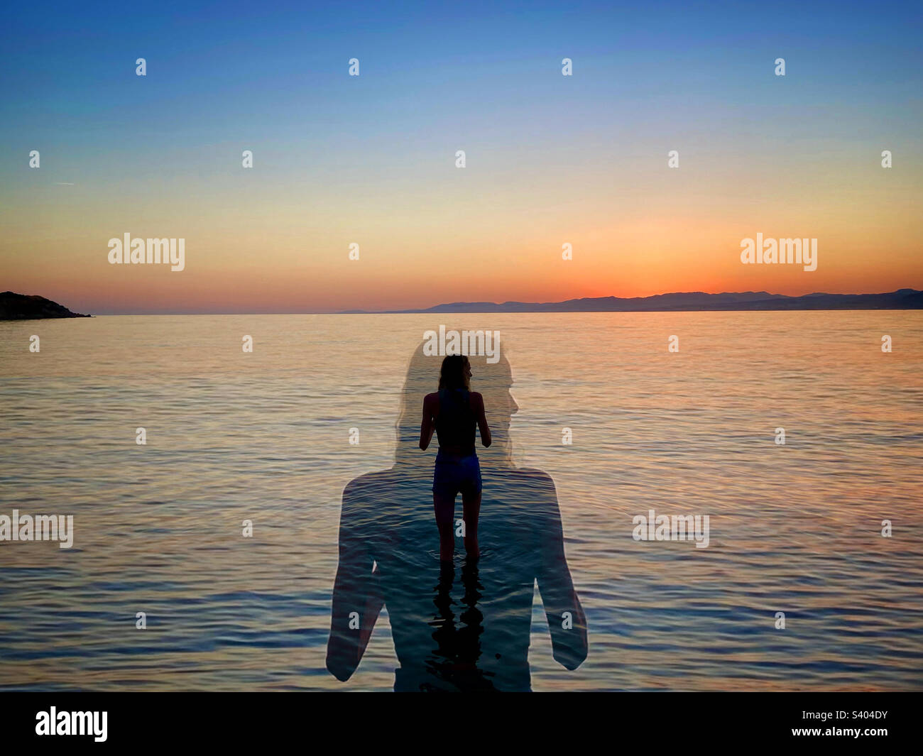 Lone girl standing in sea at sunset on Rhodes, Greece - Smartphone Captured Stock Image
