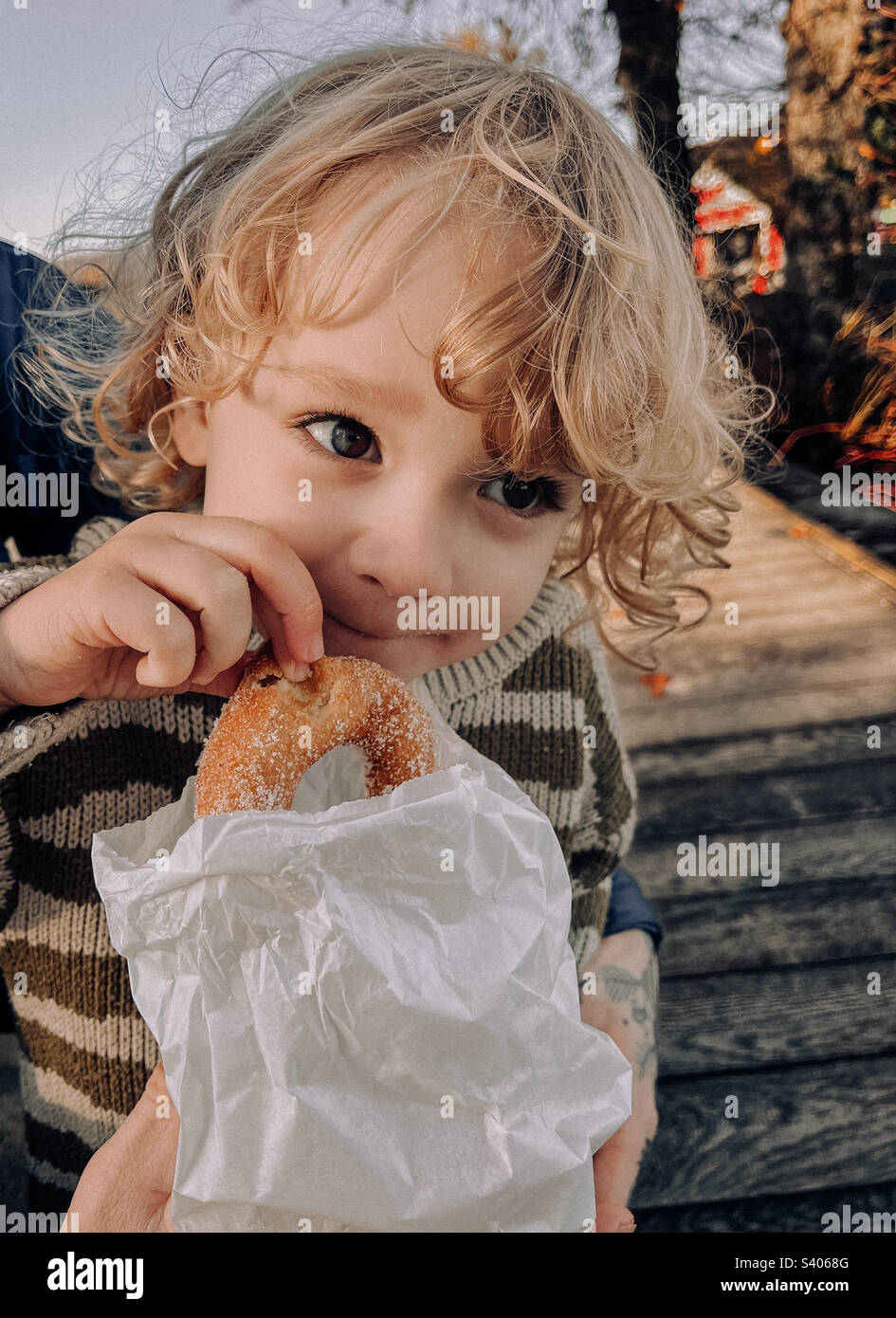 Toddler eating doughnut cute Stock Photo