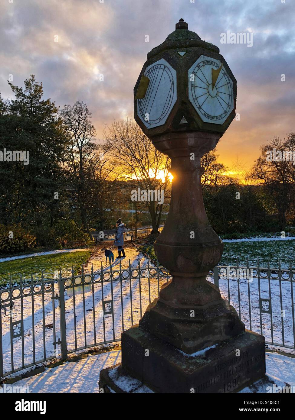 Sundial in the park with winter snow on the ground at sunset - Smartphone Captured Stock Image