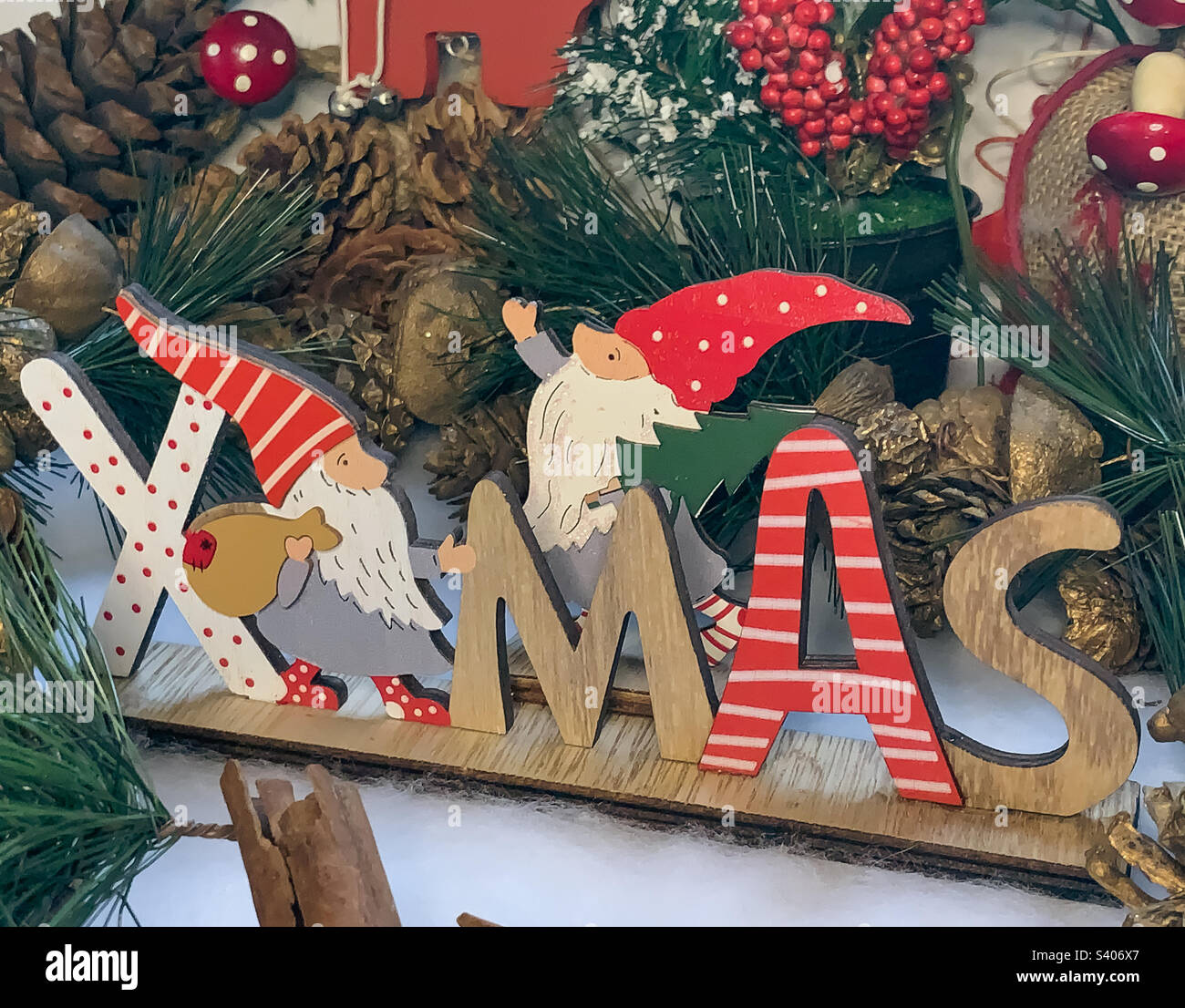 Wooden sign spelling Xmas, with pinecones and holly - Smartphone Captured Stock Image