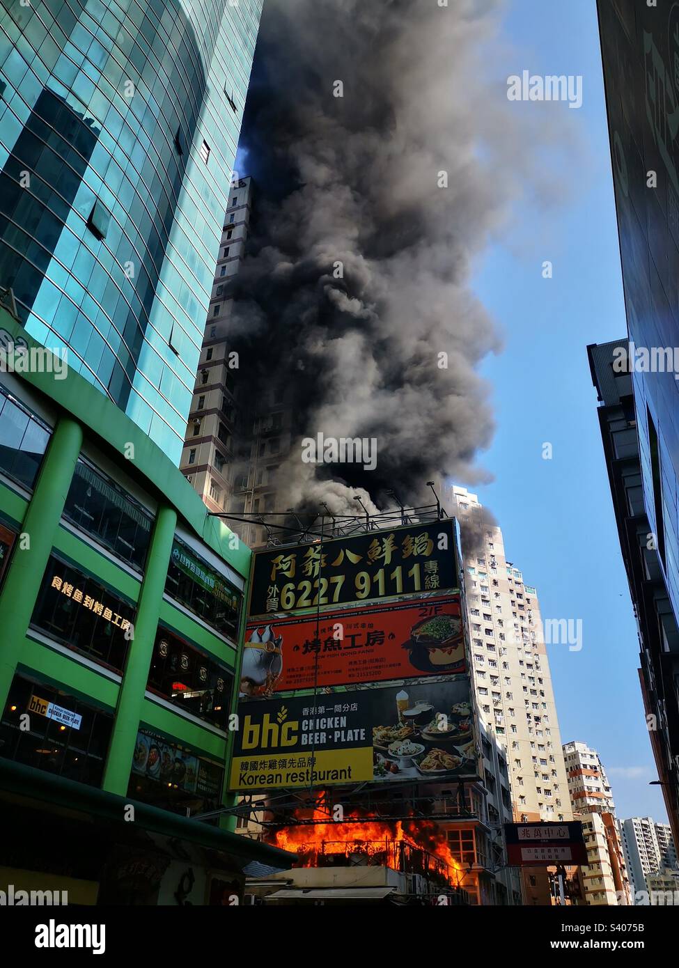 December 10th,2022. Mong Kok, Kowloon,Hong Kong. Hung Fai building covered with thick black smoke after a large fire broke out in the late morning hours. - Smartphone Captured Stock Image