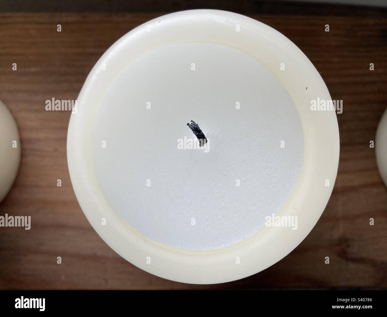 A round white candle with black wick from above - Smartphone Captured Stock Image
