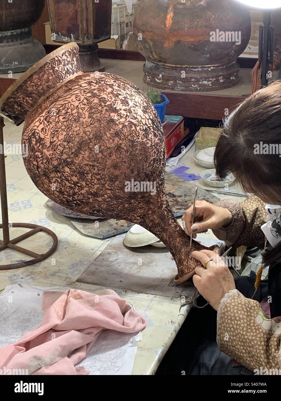 Woman artist doing the Chinese cloisonné design on vase in China Stock Photo