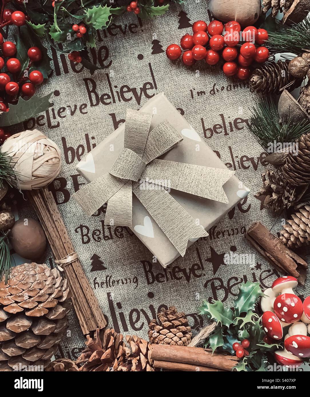 Festive flat lay of decorations centred around a wrapped present - Smartphone Captured Stock Image