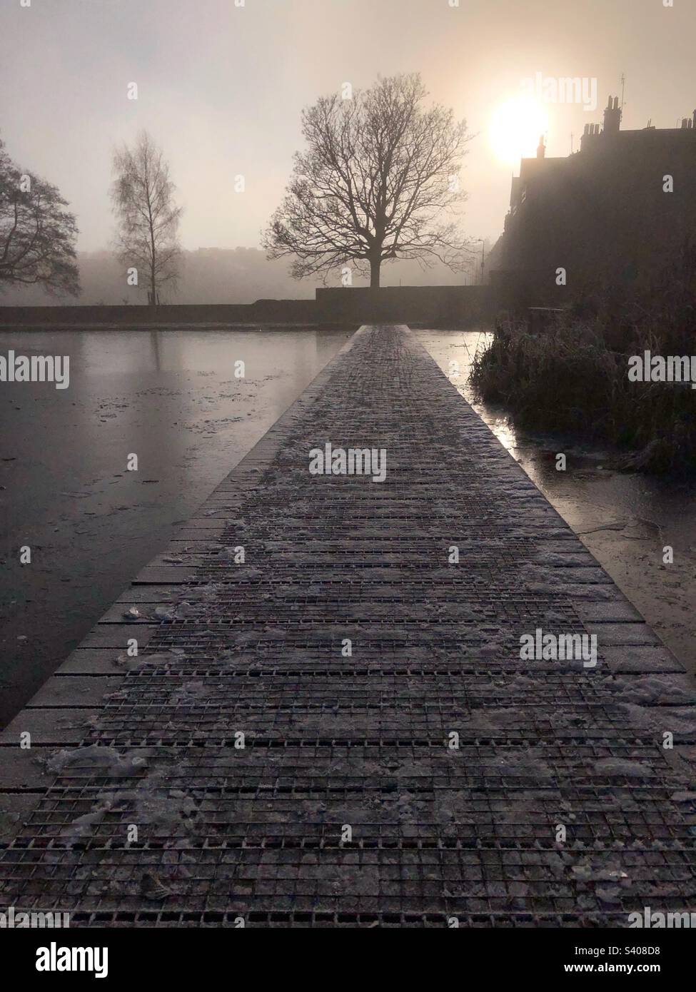 Freezing fog and boardwalk over a Frozen pond in Inverleith park, Edinburgh - Smartphone Captured Stock Image