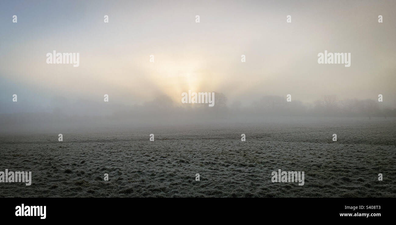 Winter sun tries to break through low winter mist over frosty fields in rural Gloucestershire, UK. A mobile phone photo with some phone or tablet post processing. - Smartphone Captured Stock Image