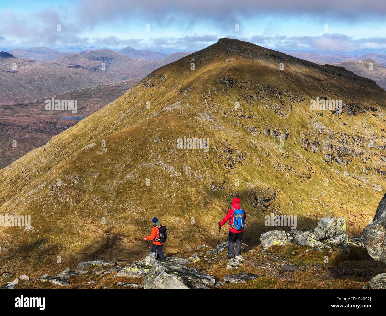 Walkers leaving the summit of Munro Stob Binnein, with a view towards the adjacent peak of Ben More, Crianlarich Scotland - Smartphone Captured Stock Image