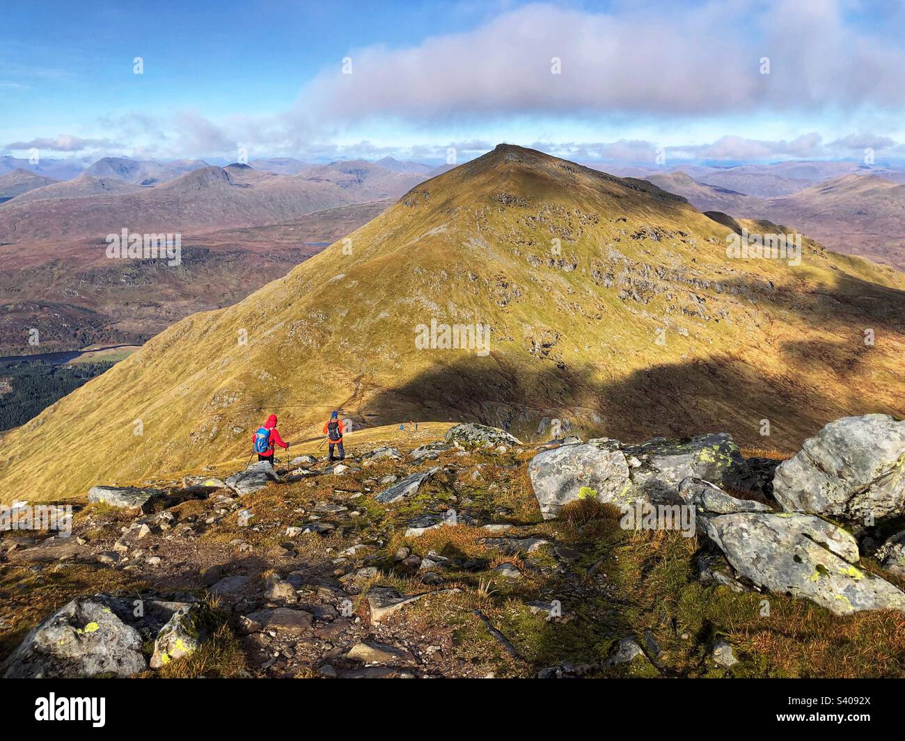 Walkers leaving the summit of Munro Stob Binnein, with a view towards the adjacent peak of Ben More, Crianlarich Scotland - Smartphone Captured Stock Image