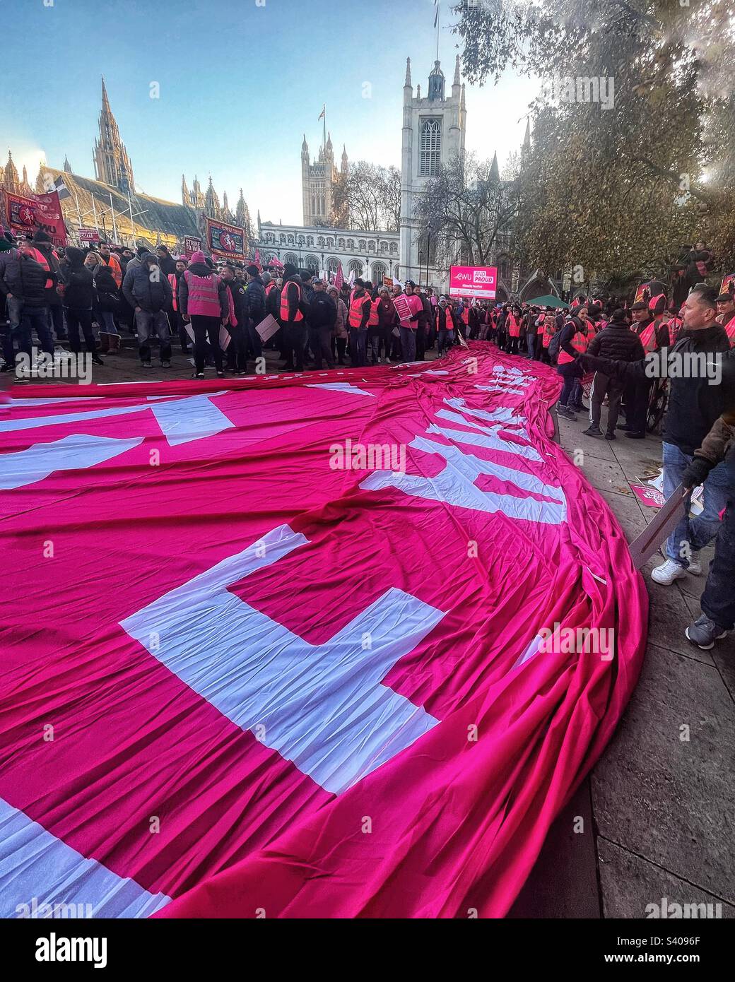 Huge pink flag on the ground during CWU protest in Parliament Square London with Westminster Abbey and House of Lords in the background - postal strike December 2022 - Smartphone Captured Stock Image