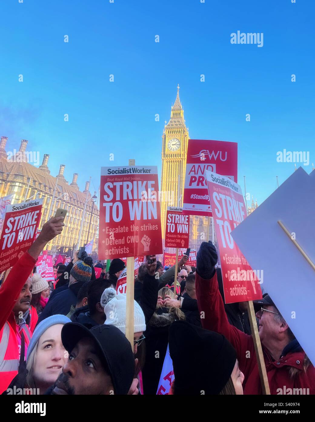Strike rally in Parliament Square for postal workers Elizabeth Tower, Big Ben clearly seen with placards calling Strike to win in support for CWU trade union - Smartphone Captured Stock Image