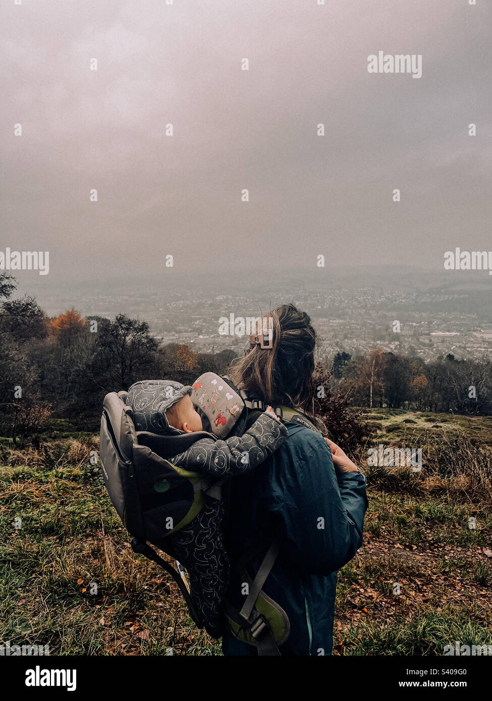 Baby in back carrier on walk outdoors Stock Photo Alamy