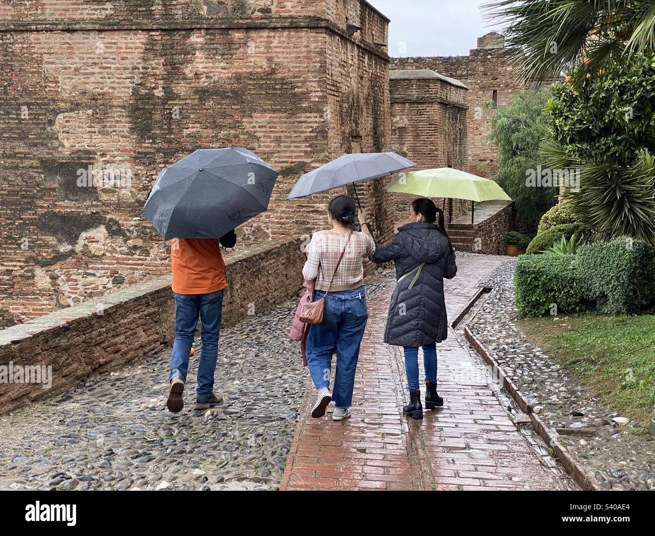 Tourists visiting the Malaga Alcazar in the rain - Smartphone Captured Stock Image