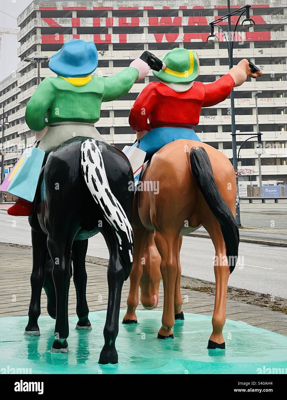 Two cowboys with guns by artist duo, Sonder, and Stop Wars graffiti on Haus der Statistik Building facade, Otto Braun Straße, Mitte, Berlin - Smartphone Captured Stock Image