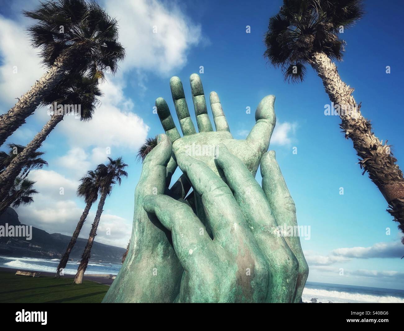 Giant Hand Sculpture memorial in Las Palmas, Gran Canaria surrounded by Palm trees - Smartphone Captured Stock Image