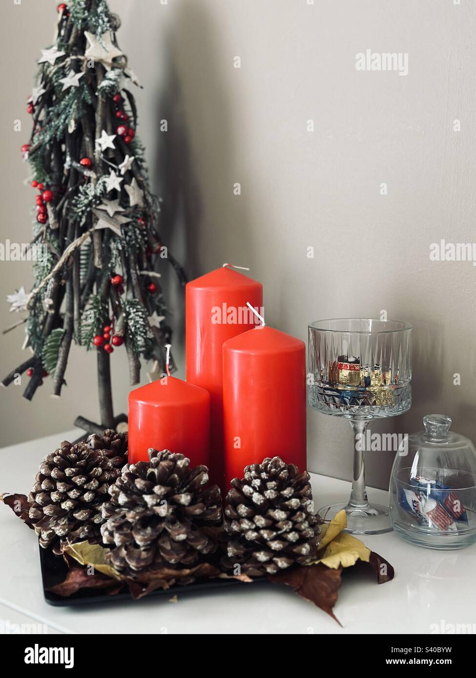 Christmas decorations - red candles, Christmas tree, pine cone and chocolate bowls - Smartphone Captured Stock Image