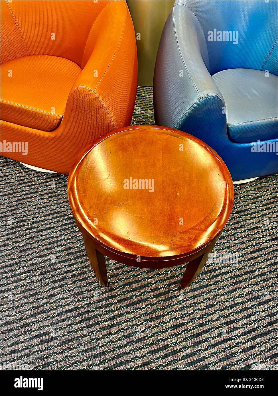 Colorful seating area with puffy chairs and round wooden coffee table. Includes print space. - Smartphone Captured Stock Image
