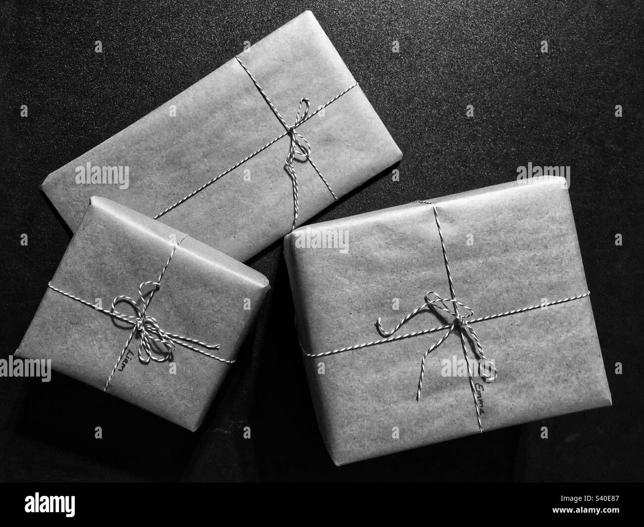 Black and white photo of gifts wrapped in paper and string - Smartphone Captured Stock Image