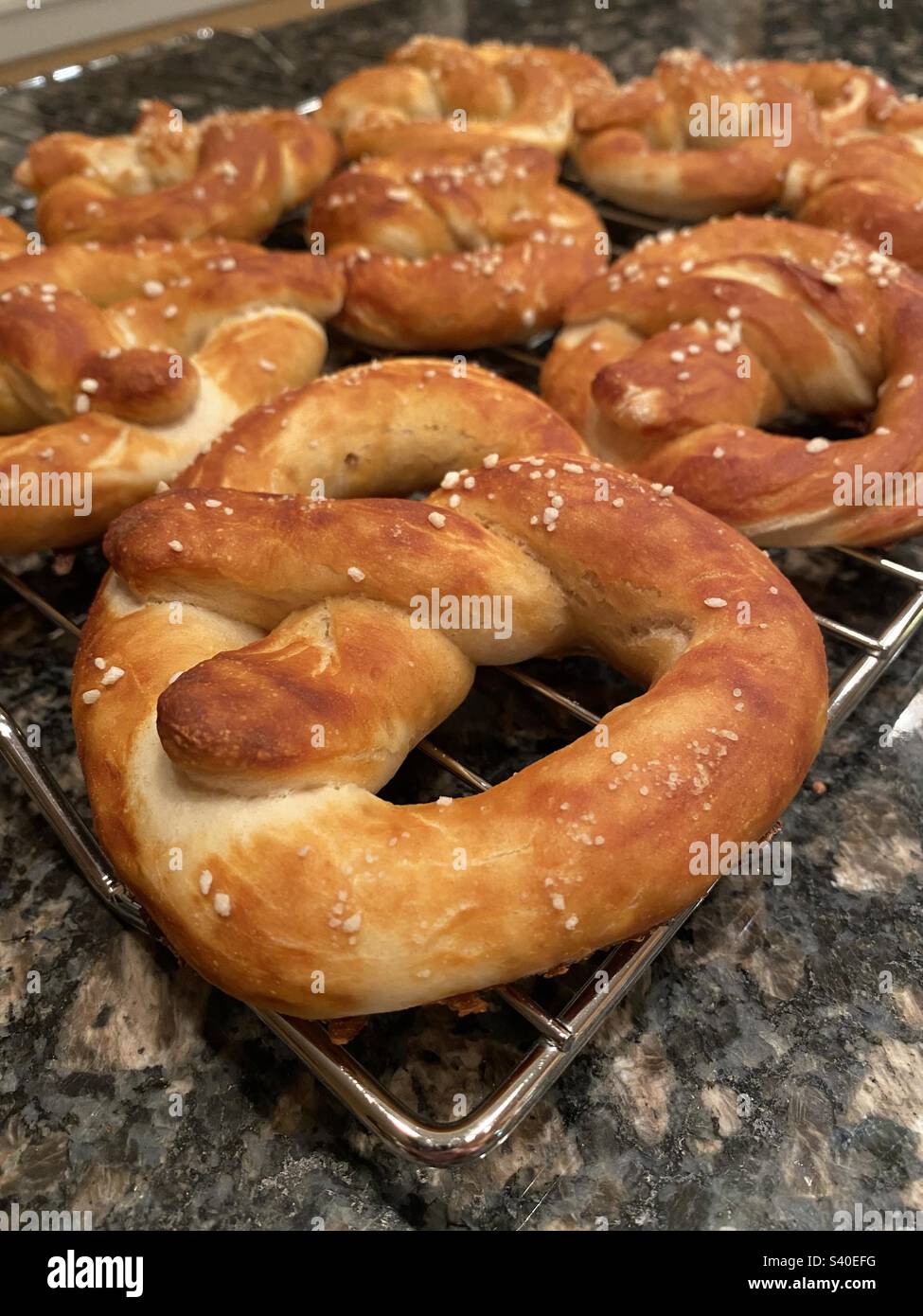 Freshly baked pretzels on a metal cooling rack - Smartphone Captured Stock Image