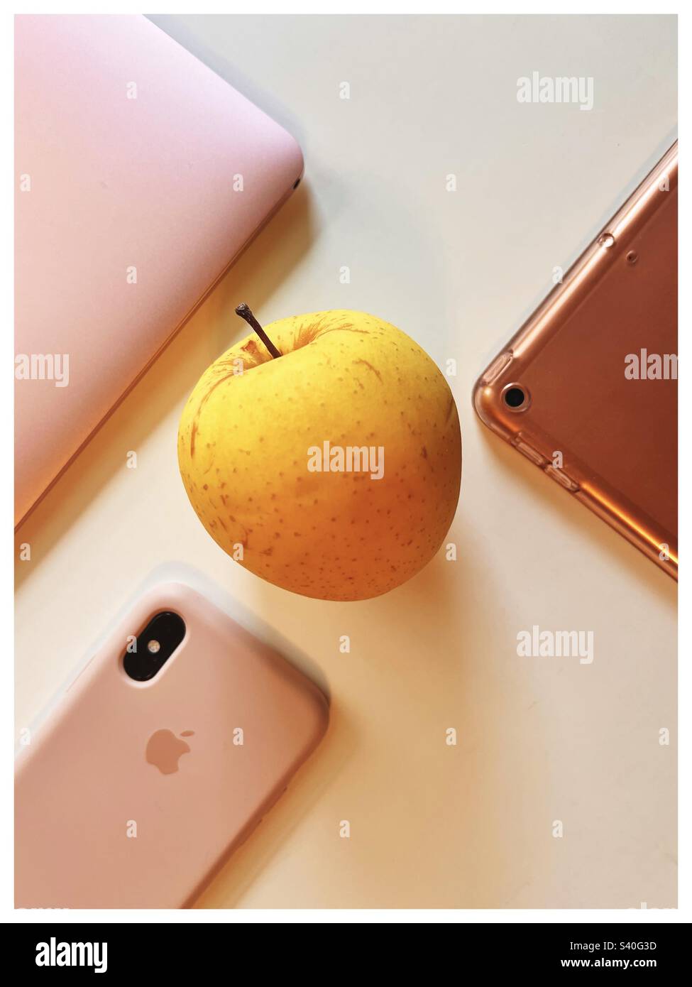 Apple products and the yellow delicious apple - Smartphone Captured Stock Image