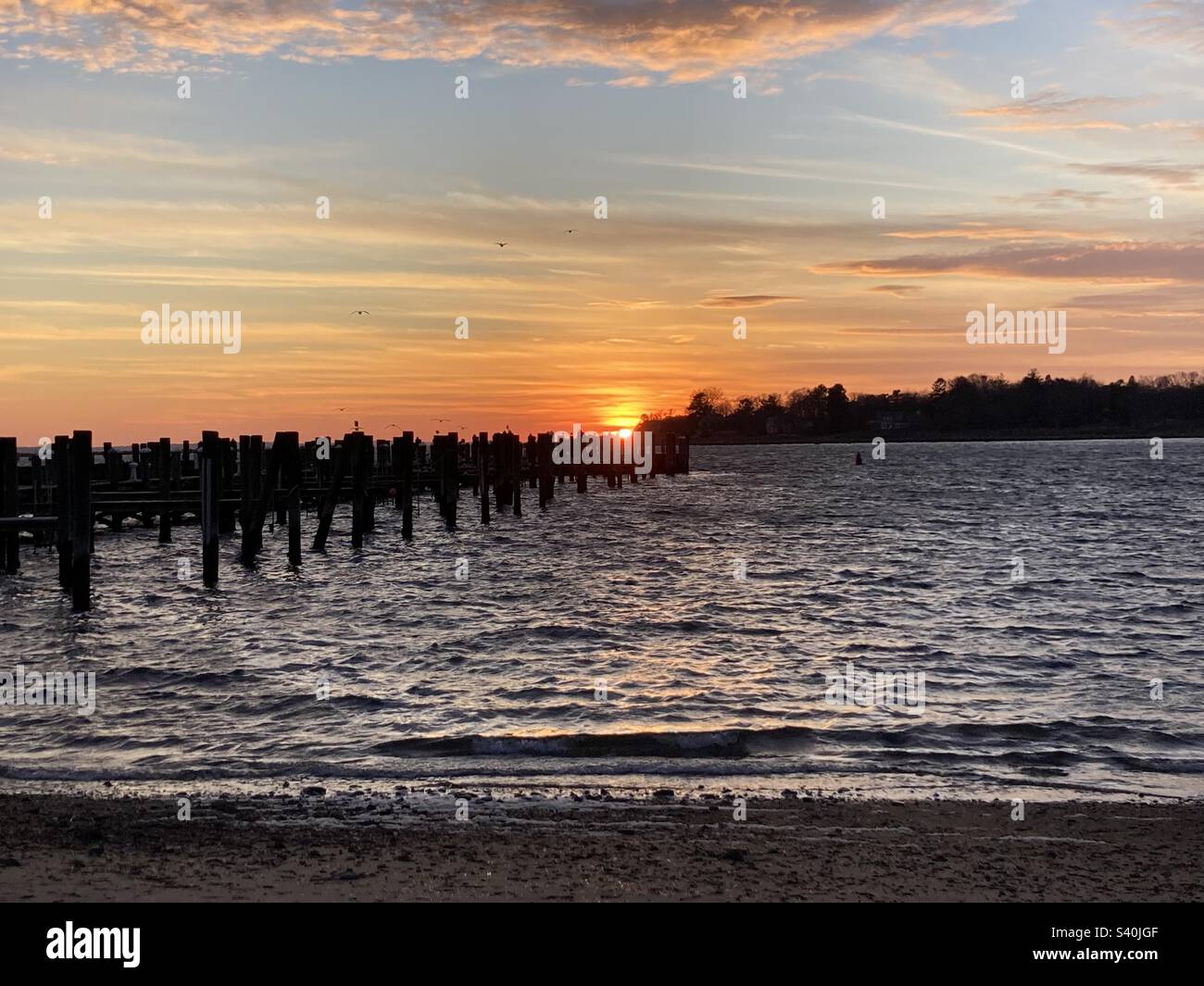 Gorgeous sunset in Stonington, Connecticut during winter. In the harbor near the pier. Birds flying in the sky. - Smartphone Captured Stock Image Gorgeous sunset in Stonington, Connecticut during winter. In the harbor near the pier. Birds flying in the sky. - Smartphone Captured Stock Image
