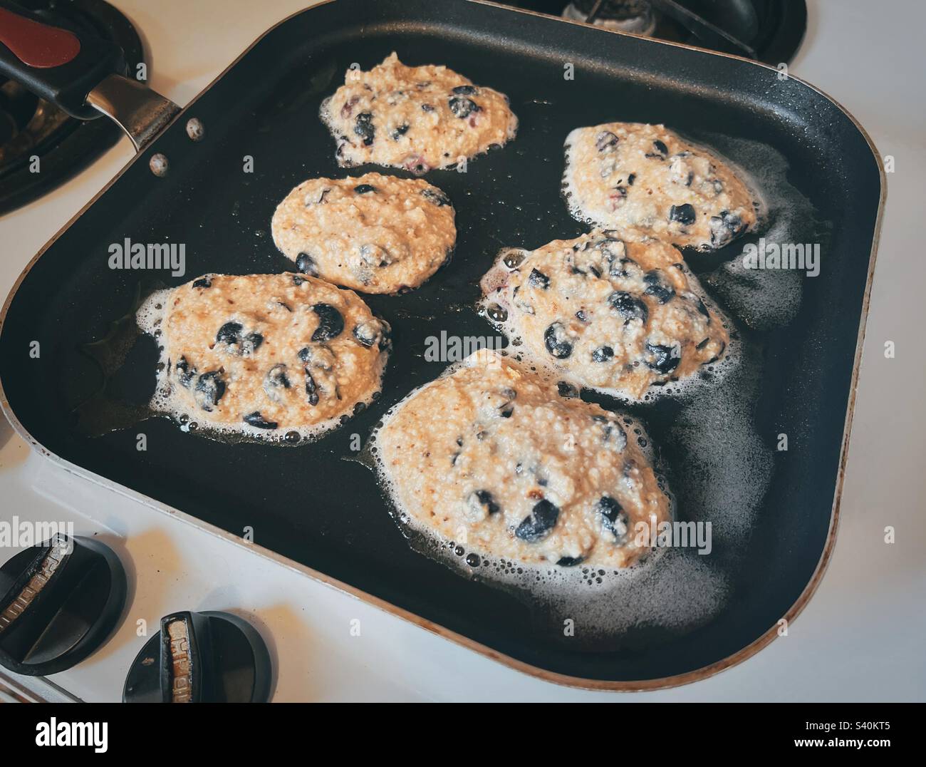 Matzoh meal blueberry pancakes on the frying pan Stock Photo