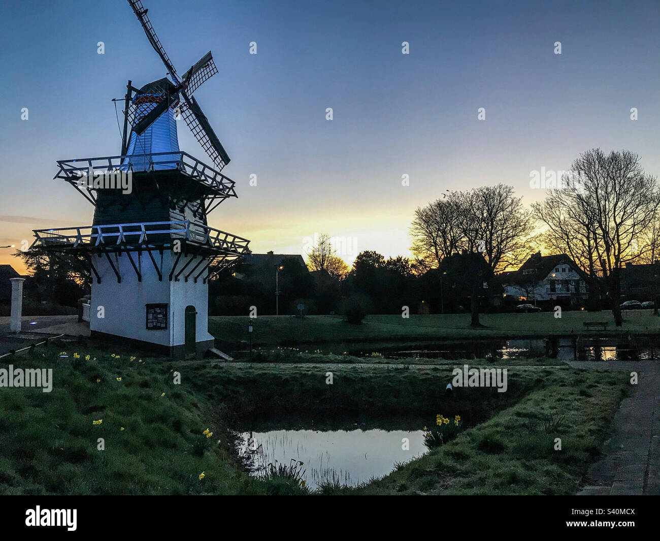 Dutch windmill at sunrise lake landscape Stock Photo