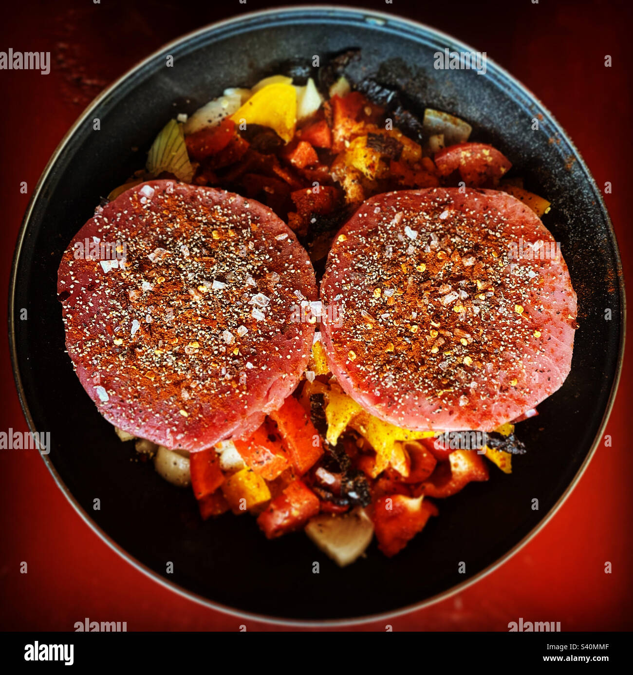 Two tuna pieces with herbs and sweet peppers cooking in Queretaro, Mexico Stock Photo