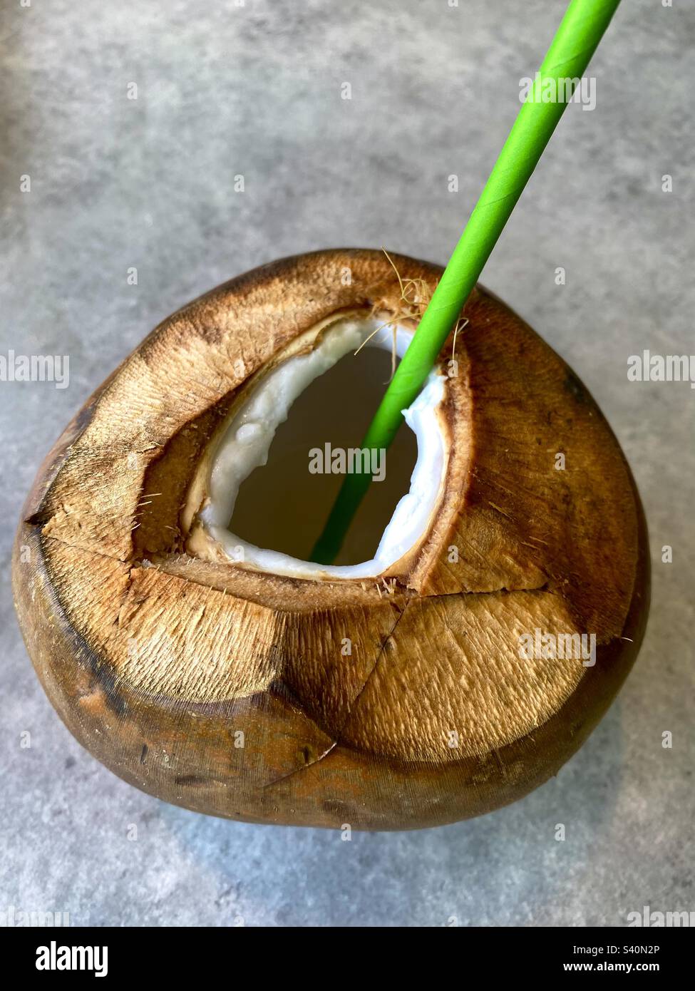 Coconut with a green straw Stock Photo