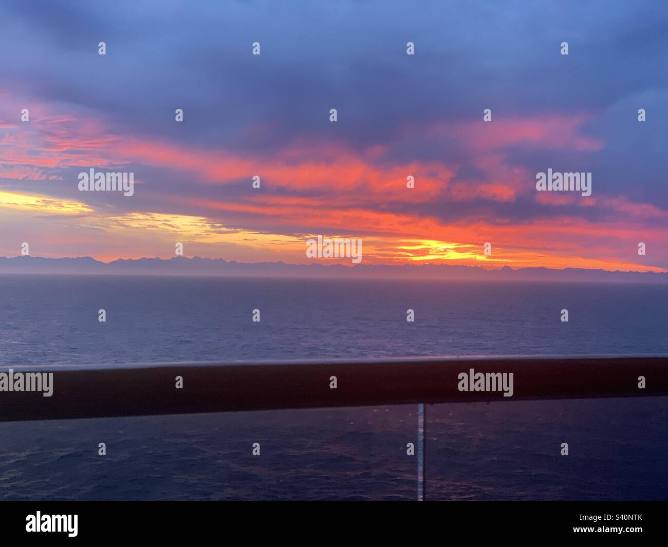 August, 2022, Sunrise view from a balcony on a cruise ship sailing past British Columbia on the way to Alaska - Smartphone Captured Stock Image