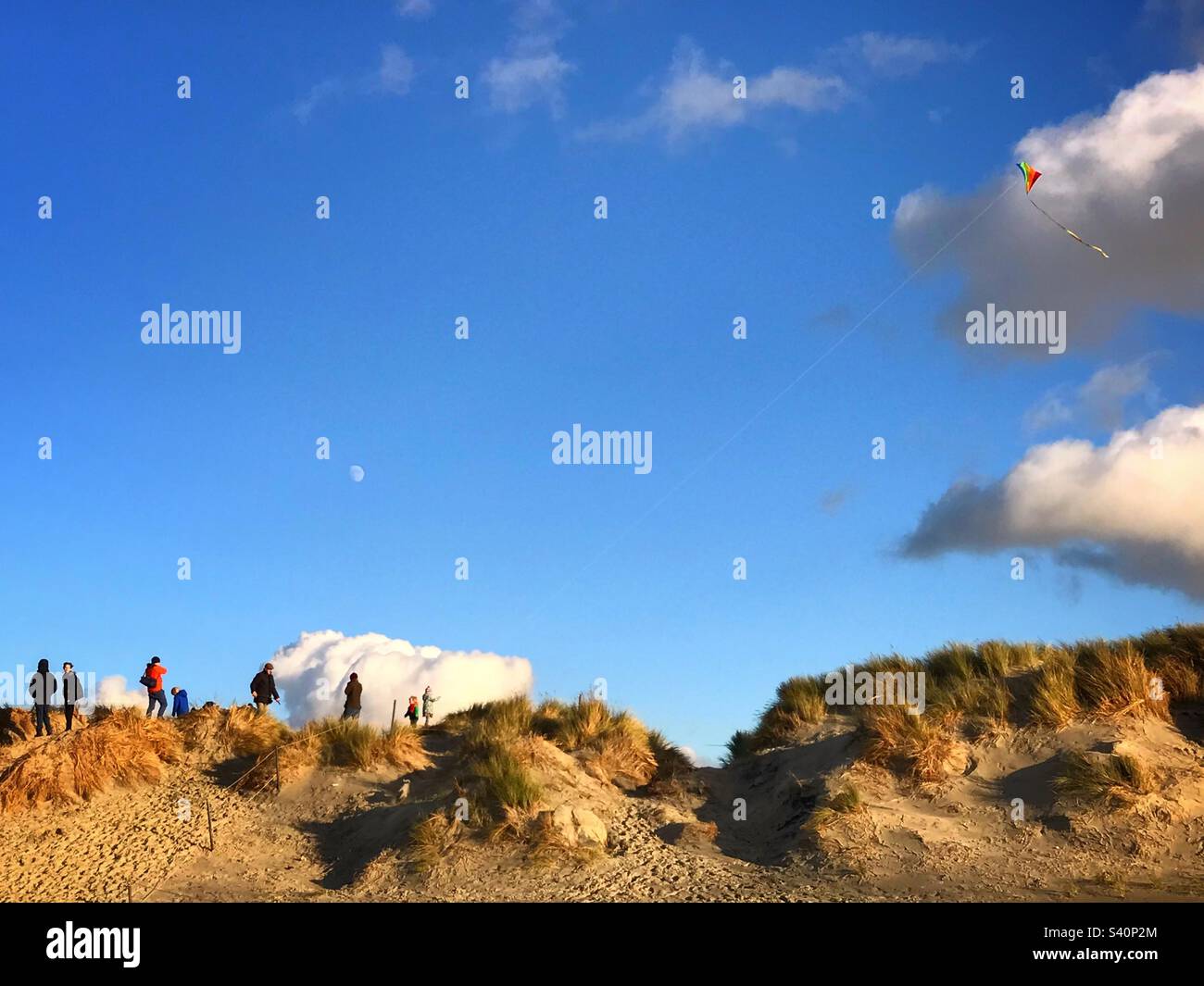 Family flying a kite on the sand dunes at East Head, West Wittering beach, West Sussex, UK - Smartphone Captured Stock Image