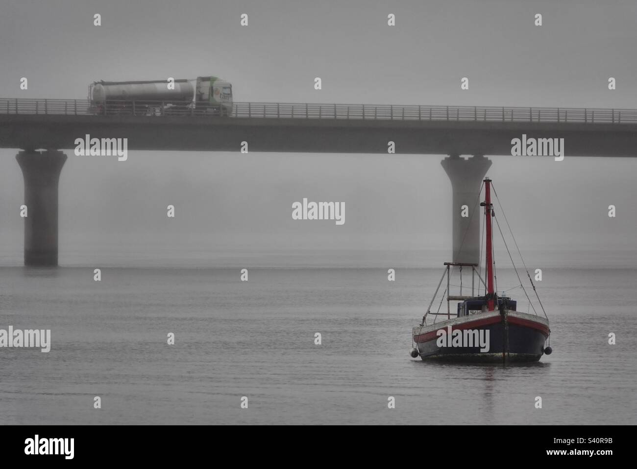 Foggy view of bridge and boat Stock Photo