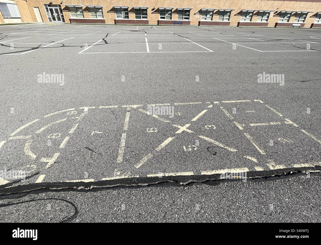 Remembered from childhood decades ago, this hopscotch, this spot on the playground, remains still, as does the elementary school itself. - Smartphone Captured Stock Image