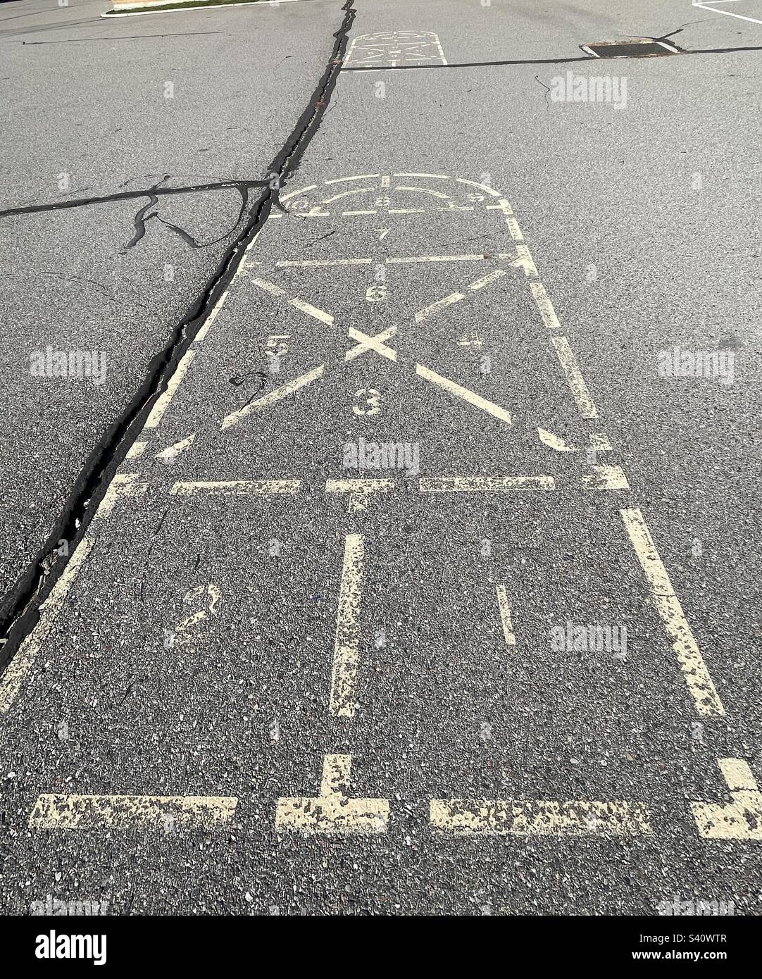 Remembered from childhood decades ago, this hopscotch, this spot on the playground, still remains, as does the elementary school itself. - Smartphone Captured Stock Image