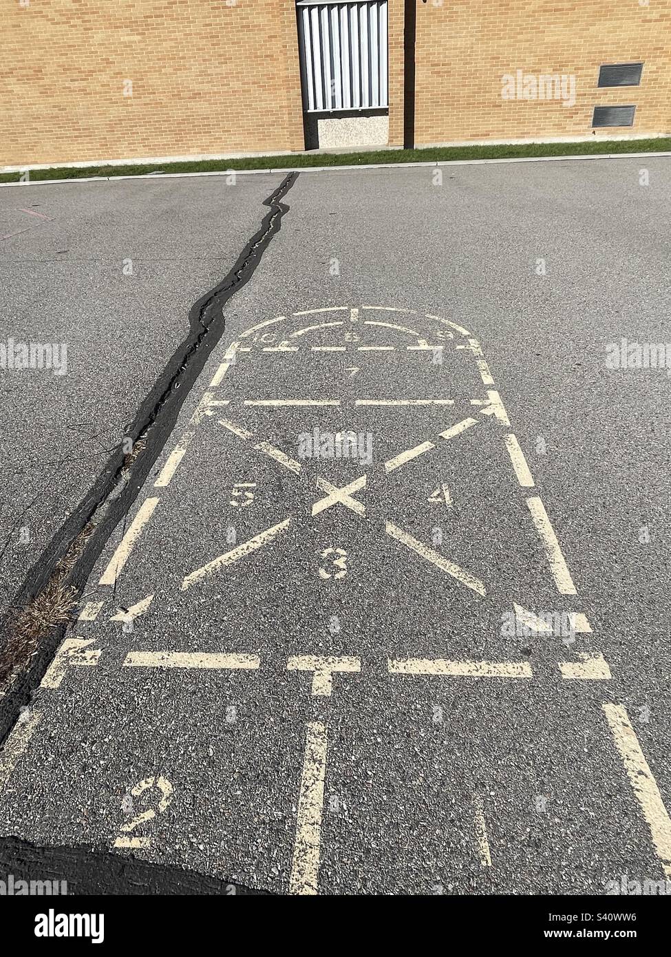 Remembered from childhood decades ago, this hopscotch, this spot on the playground, still remains, as does the elementary school itself. - Smartphone Captured Stock Image