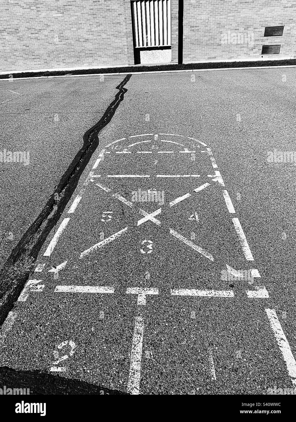 Remembered from childhood decades ago, this hopscotch, this spot on the playground, still remains, as does the elementary school itself. Stock Photo