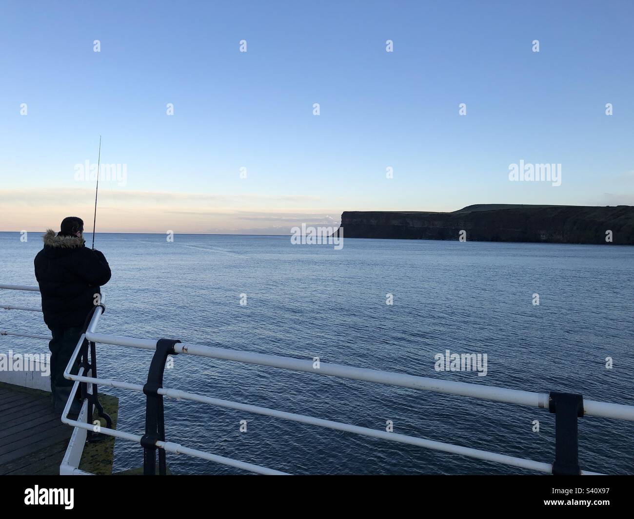 Man fish off the pier at Saltburn by the Sea, United Kingdom - Smartphone Captured Stock Image