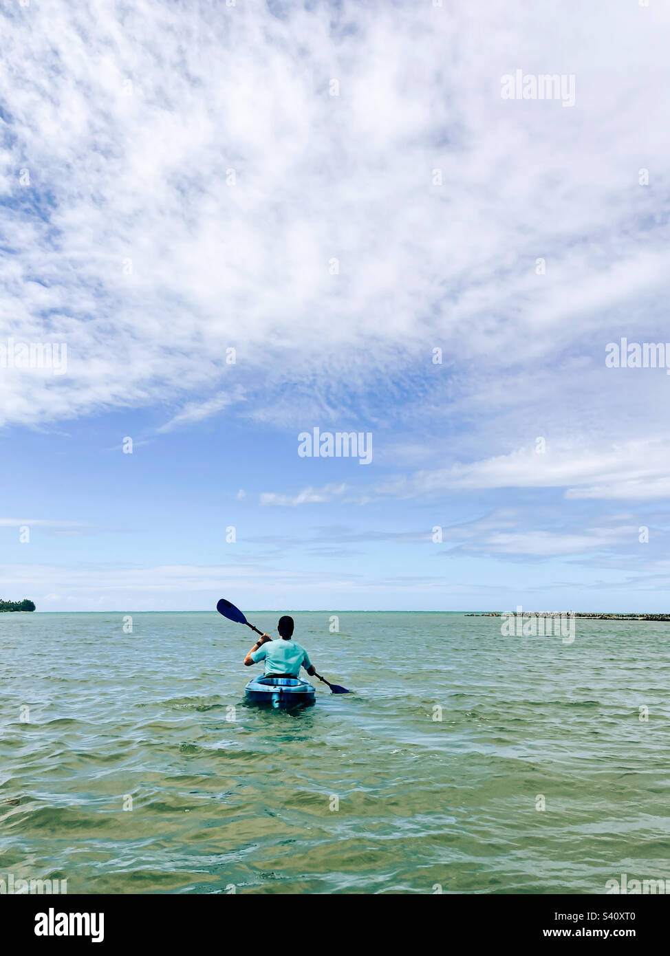 Young man kayaking in ocean Stock Photo