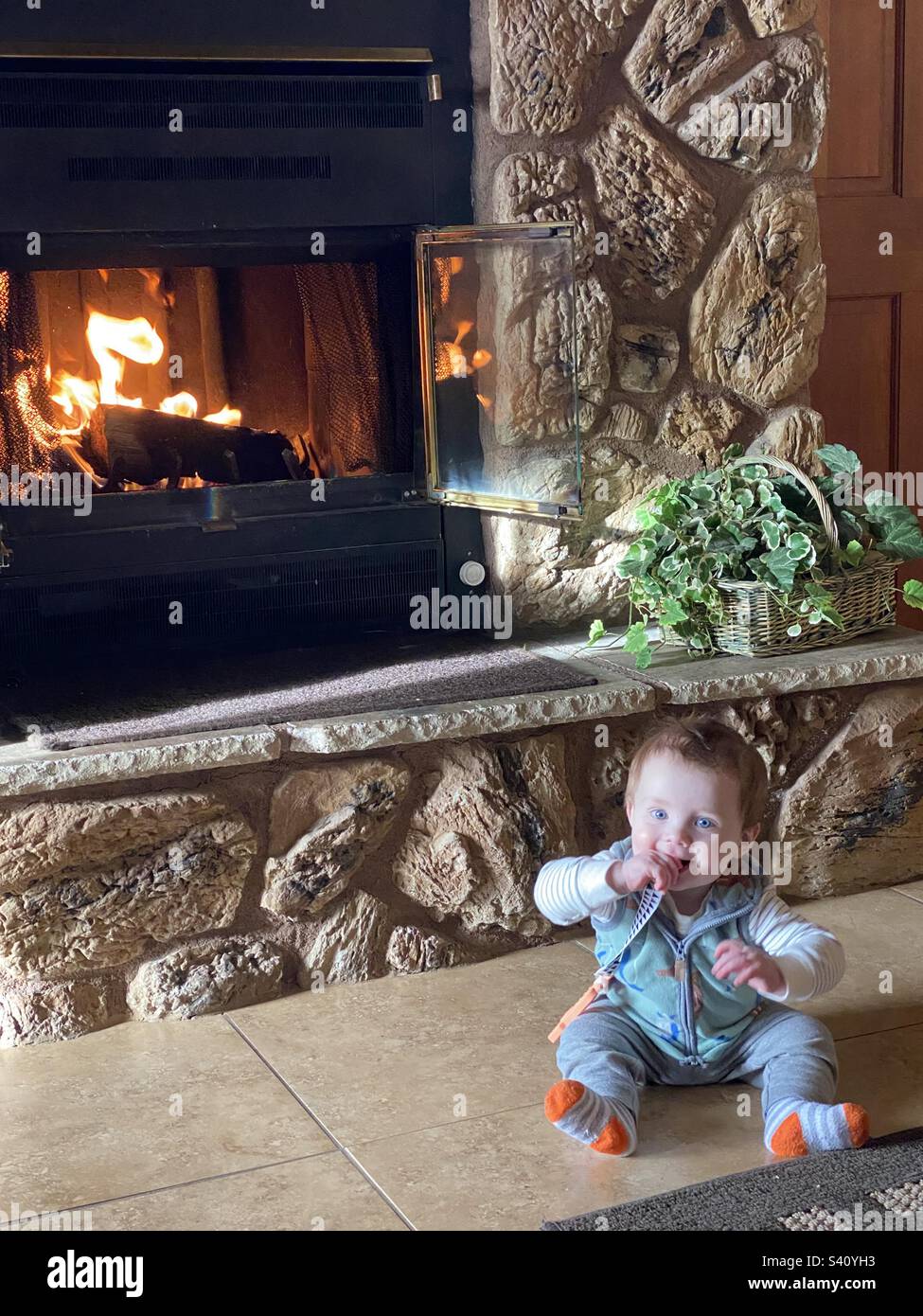 Cute infant hanging out by the fire Stock Photo