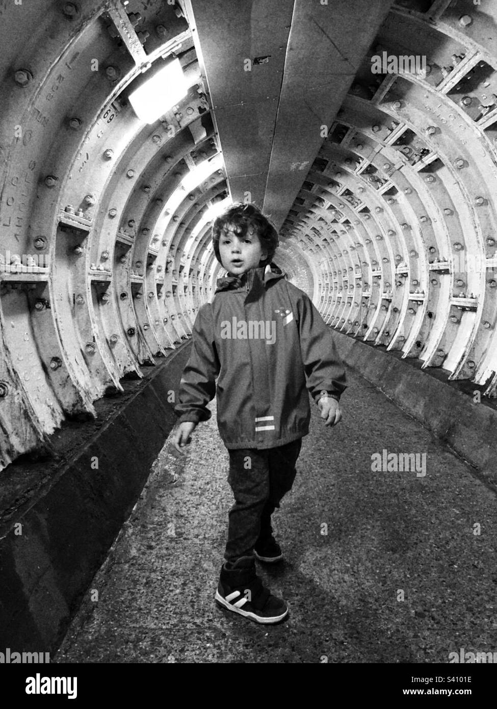 Boy in a tunnel Greenwich foot tunnel under the Thames mono black and white Stock Photo Alamy