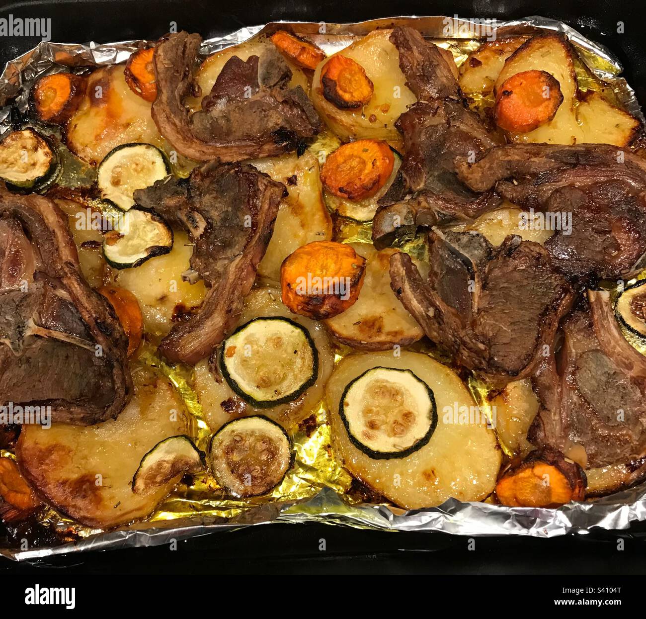 Lamb chop oven tray bake with potatoes carrots and courgettes Stock
