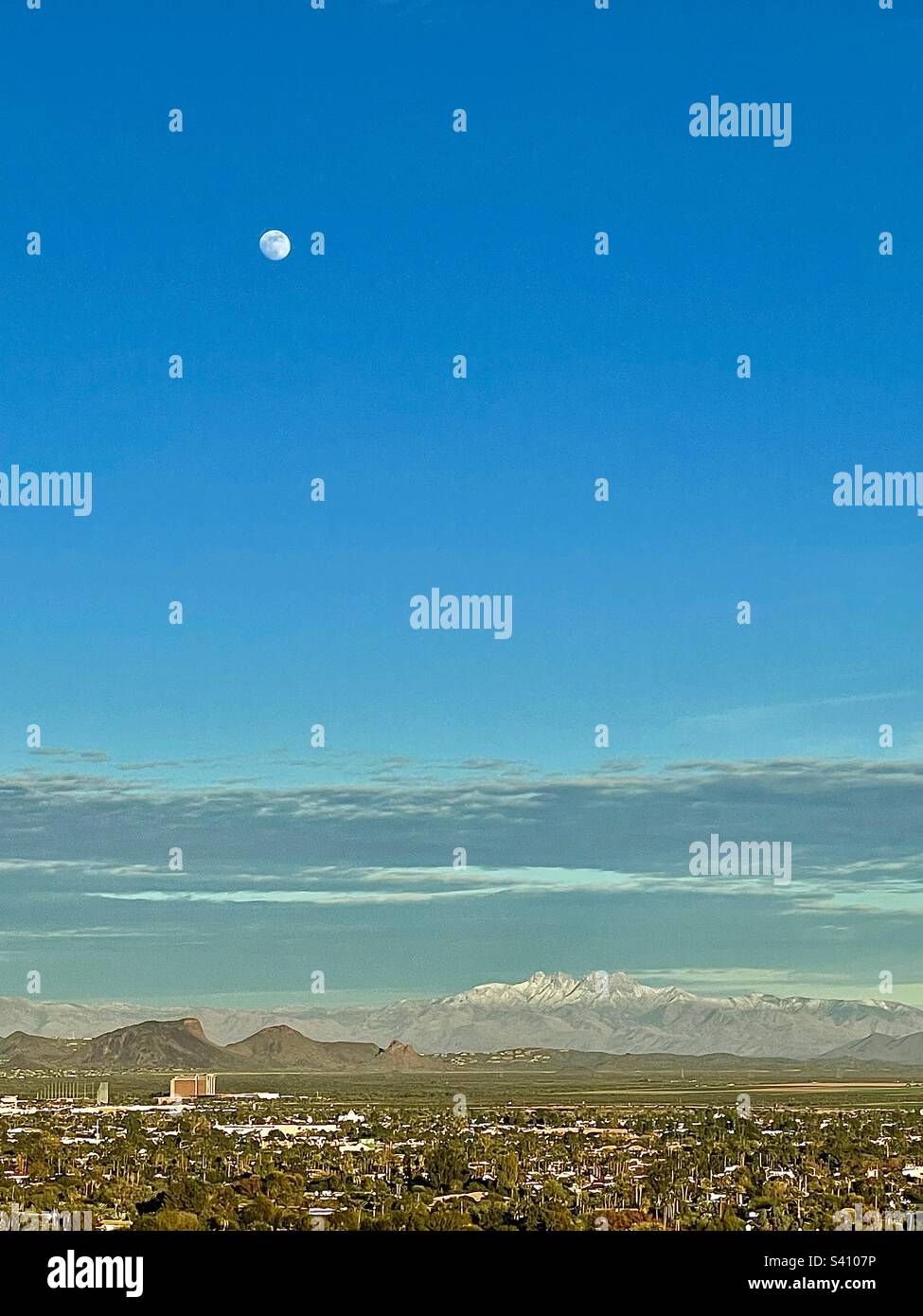 Moon over snowy Four Peaks, Eagle Mountain, Indian Reservation, Casino, Scottsdale, Phoenix Arizona, deep blue sky, green fields, suburbs, from Cholla trail, Camelback Mountain, copy space Stock Photo