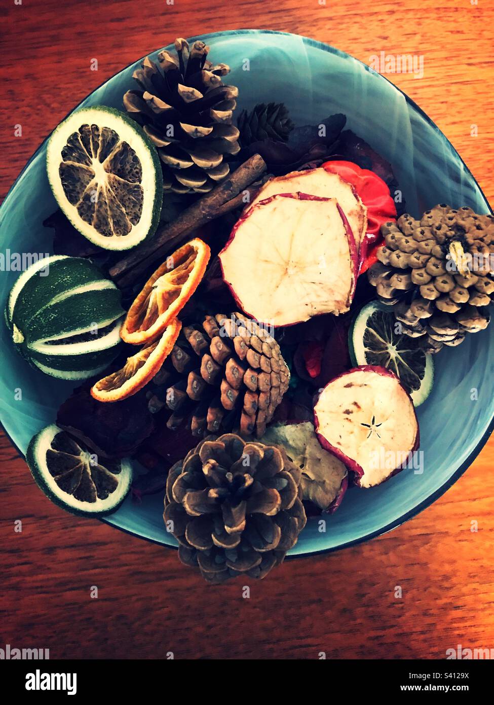 Bowl full of potpourri cones dried oranges and lemons . Making a lovely