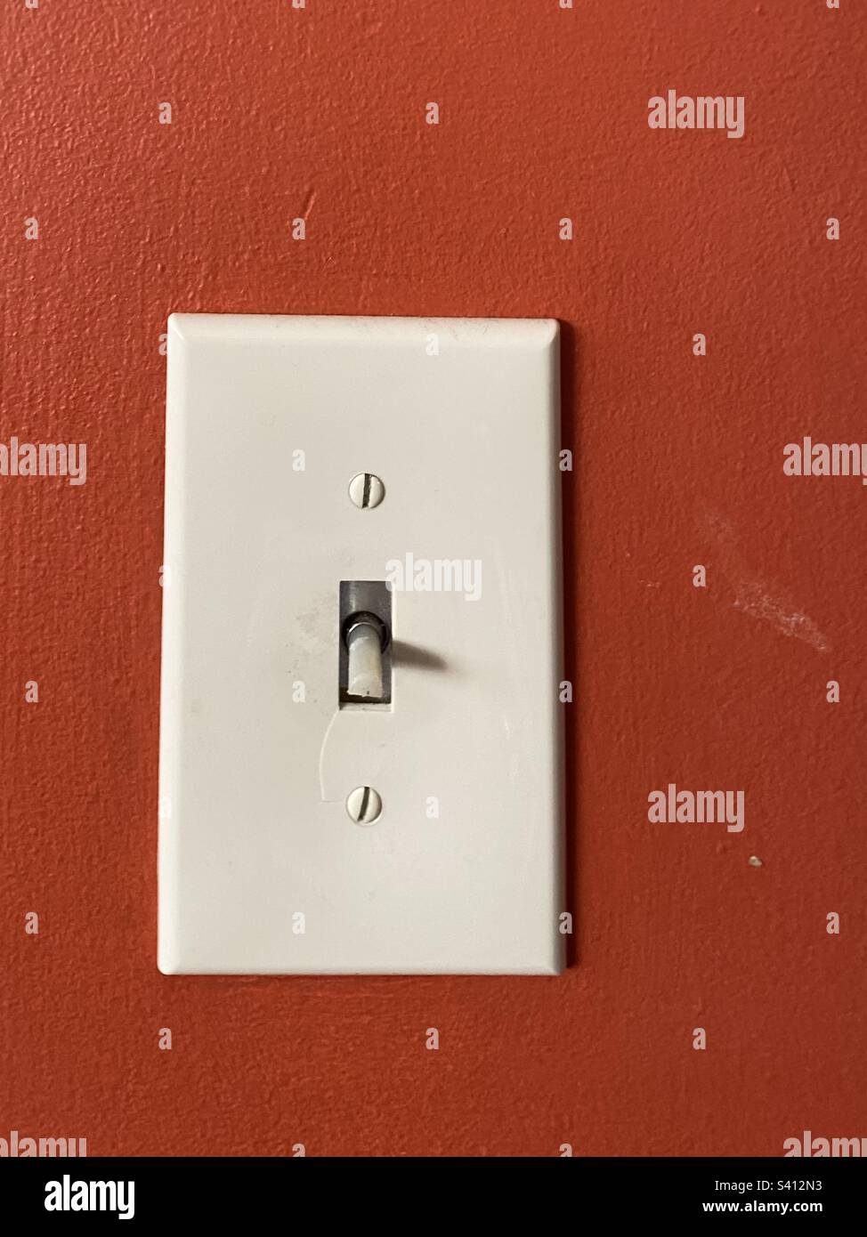 Closeup of Broken dimmer light switch on orange background Stock Photo