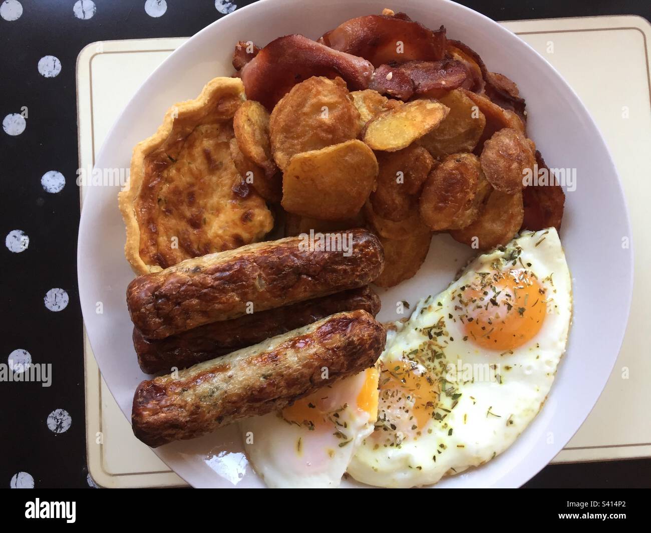 Brunch, sausages, eggs, bacon, potatoes and quiche. Stock Photo
