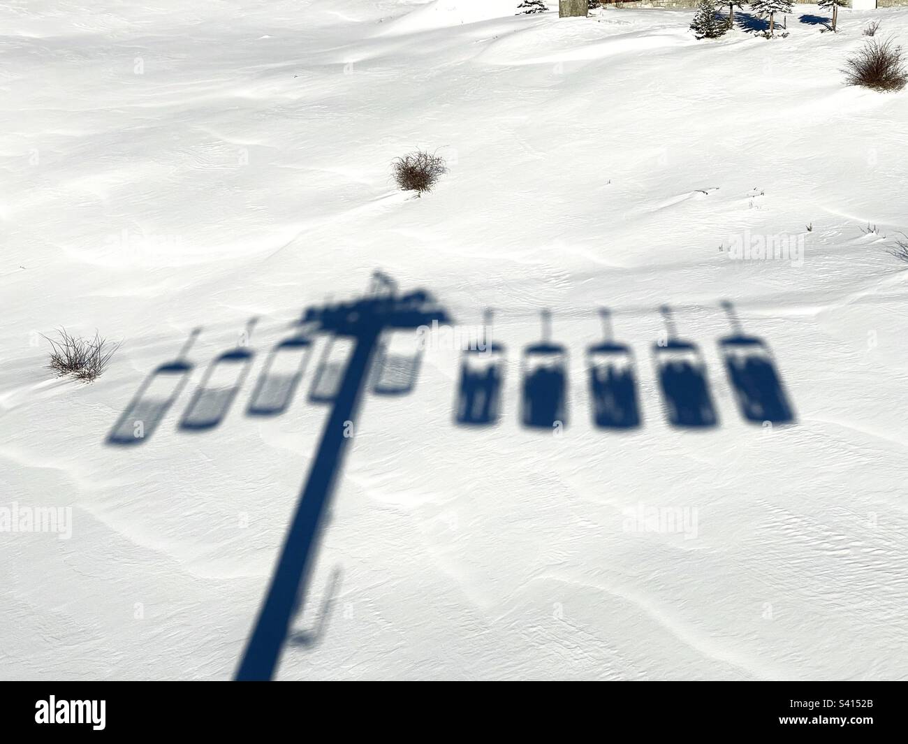 Shadow of bucket ski lifts taking people up to the ski slopes at Alpe d’Huez, France. - Smartphone Captured Stock Image