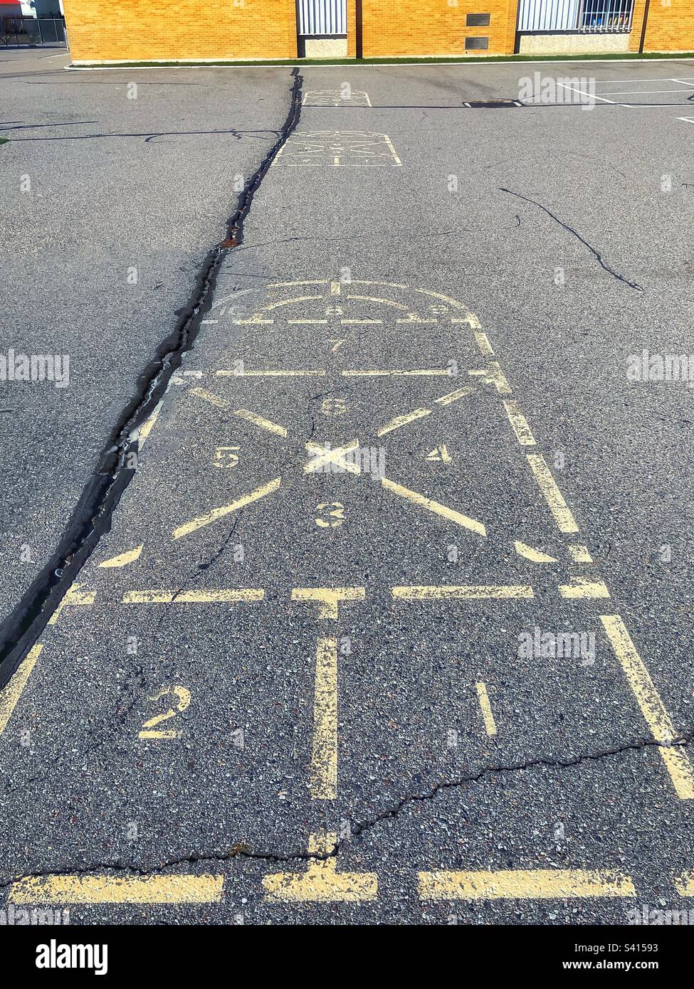 Three hopscotches in a row on a cracked and weathered playground, still seen and remembered from decades ago. - Smartphone Captured Stock Image