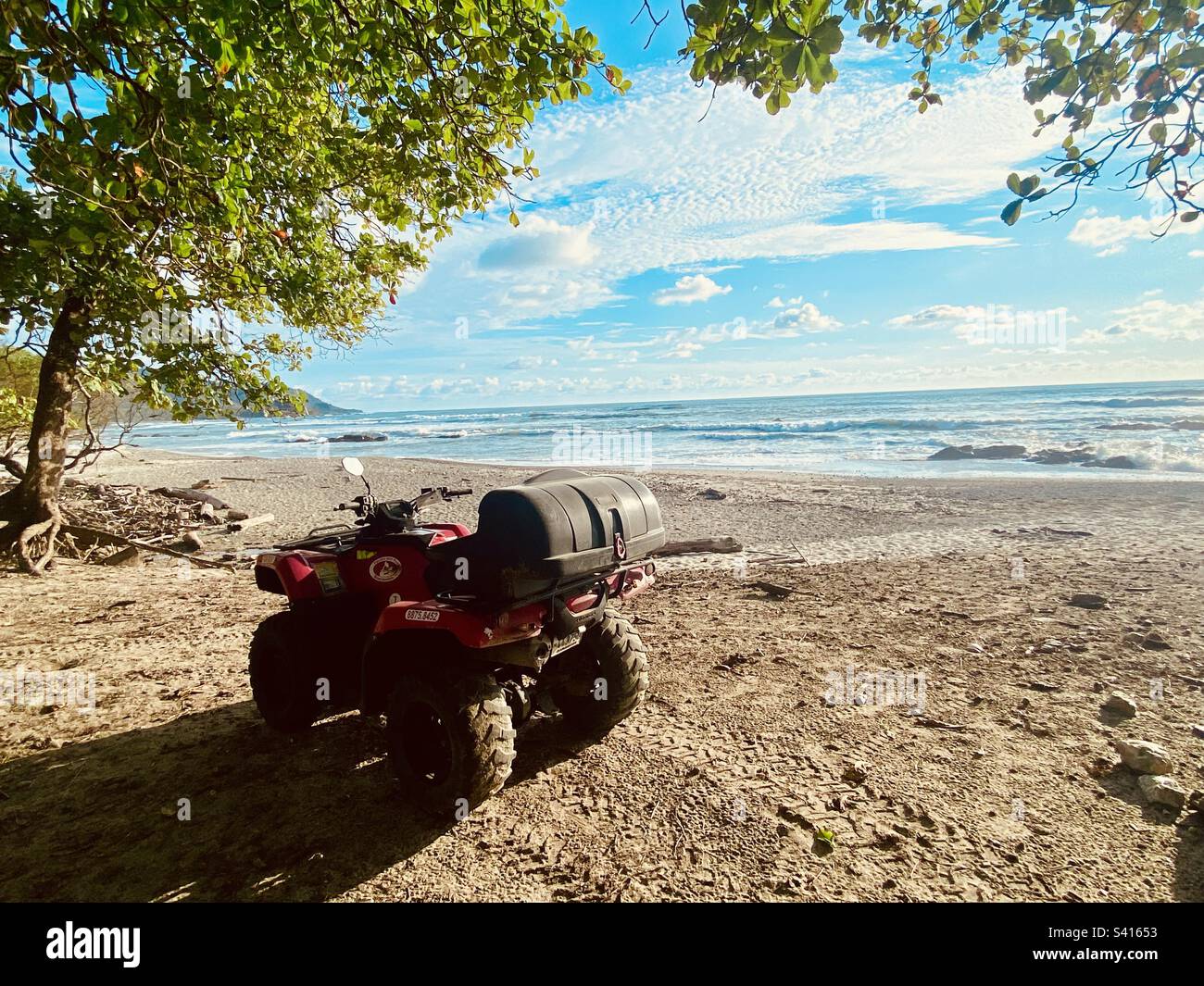 A quad bike parked up beside a perfect beach on a sunny day near Santa Teressa in Costa Rica - Smartphone Captured Stock Image