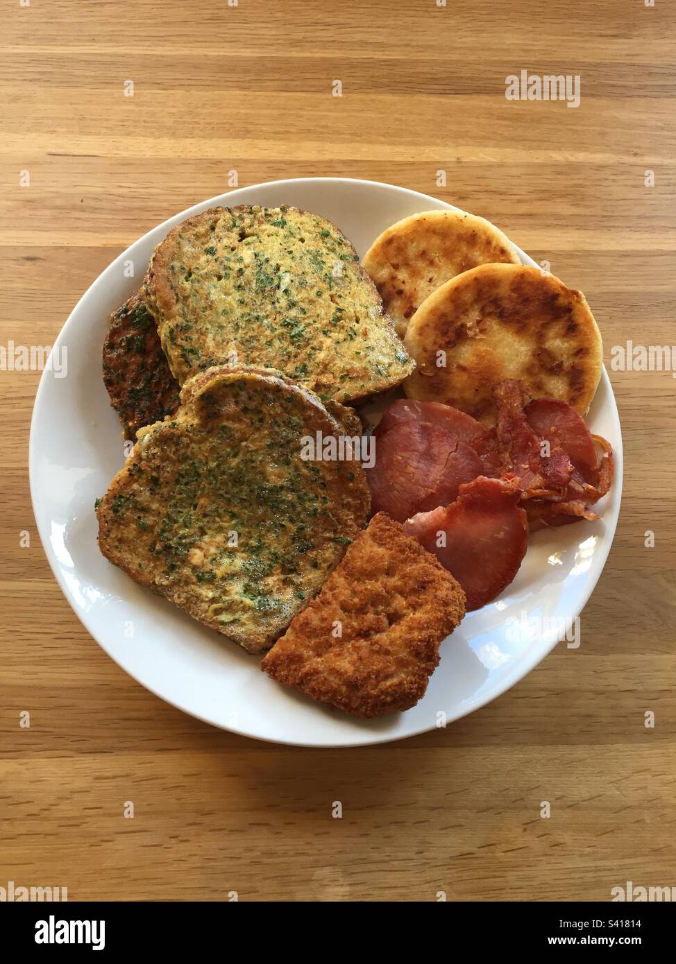 Lunch fry up with eggy bread, crispy bacon, chicken in breadcrumbs and potato cakes, pic 6. Stock Photo
